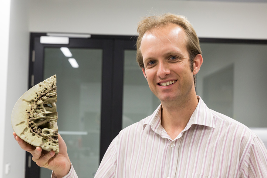 Levi Beeching holding a 3D print of a scanned bone